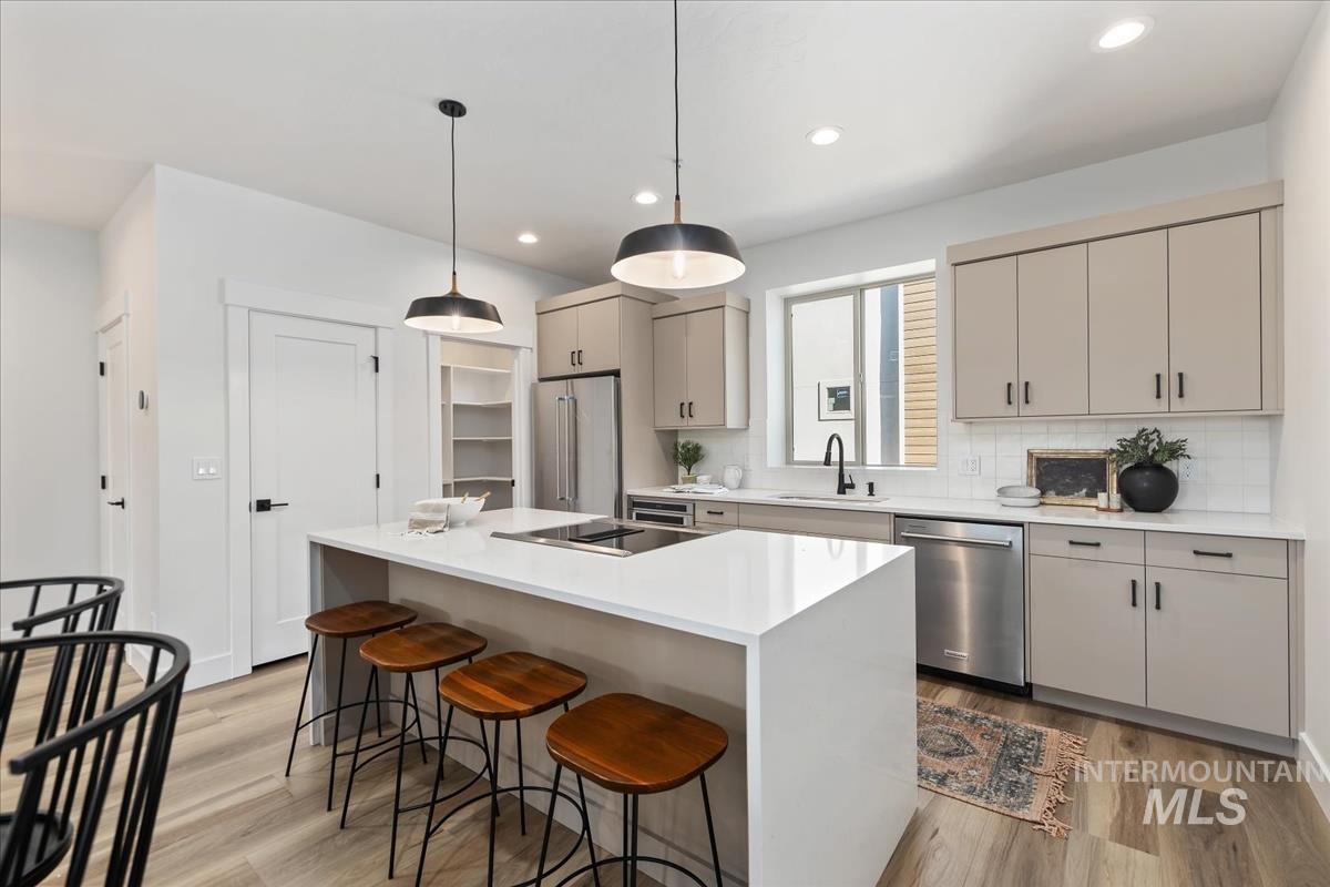 1725 South Rock View Lane, Unit 34 Boise, ID 83705 - Photo 3 of 31 Kitchen featuring appliances with stainless steel finishes, light wood-type flooring, a kitchen bar, light countertops, and recessed lighting