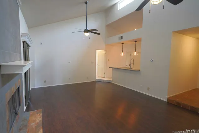 a view of empty room with wooden floor and fireplace