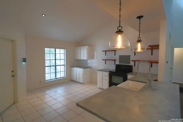 a open kitchen with white cabinets and sink