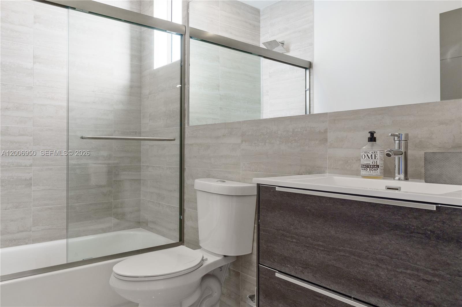 2889 Southwest 33rd Avenue, Unit 2889 Miami, FL 33133 - Photo 5 of 38 a bathroom with a sink a toilet and shower