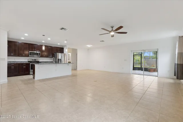 a view of an empty room with a kitchen