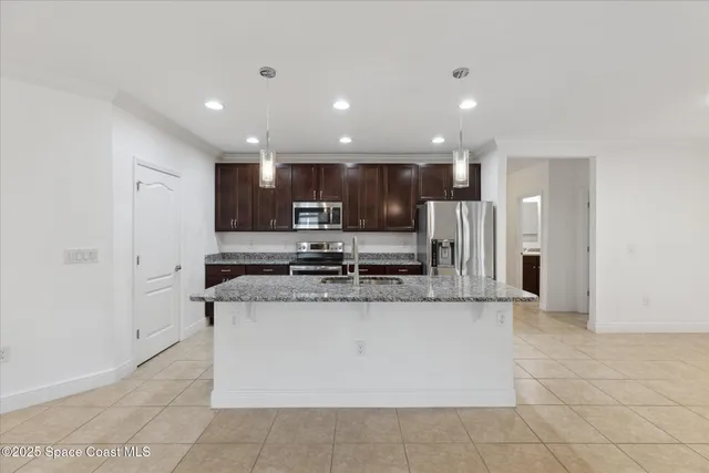 a kitchen with stainless steel appliances granite countertop a refrigerator and a stove