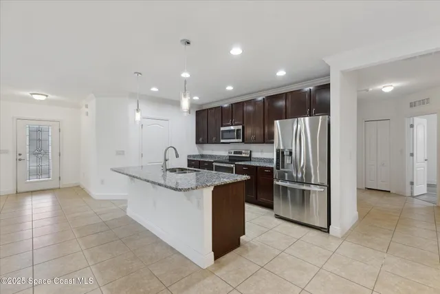 a kitchen with stainless steel appliances granite countertop a refrigerator and a sink