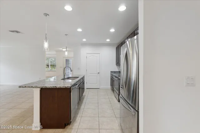 a kitchen with stainless steel appliances granite countertop a sink and a refrigerator