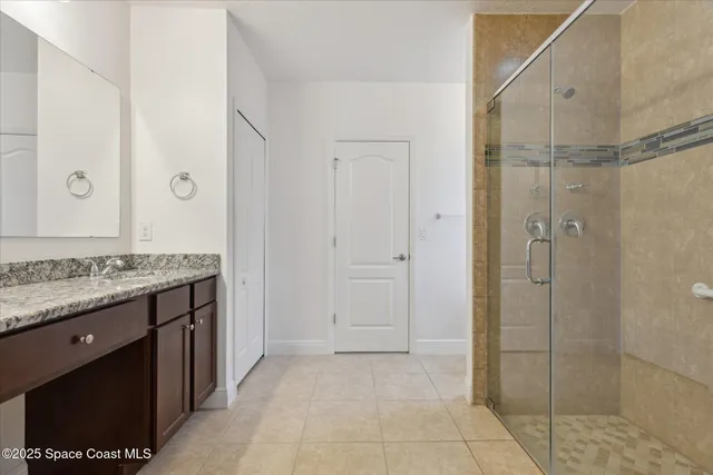 a bathroom with a granite countertop sink and shower