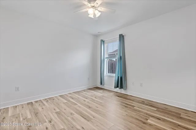 a view of a room with wooden floor and fan
