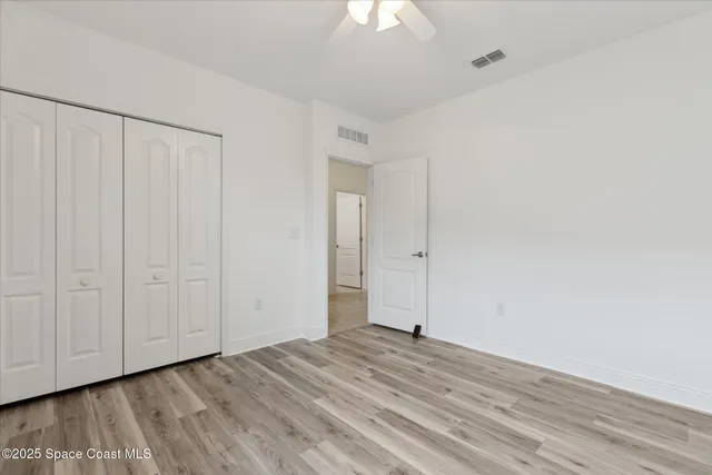 a view of a livingroom with wooden floor and a ceiling fan