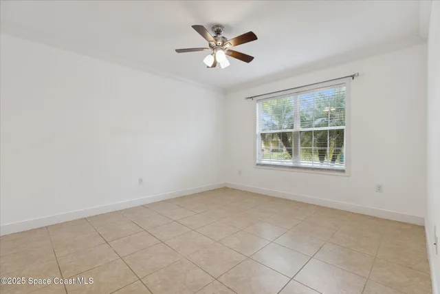 an empty room with windows and ceiling fan