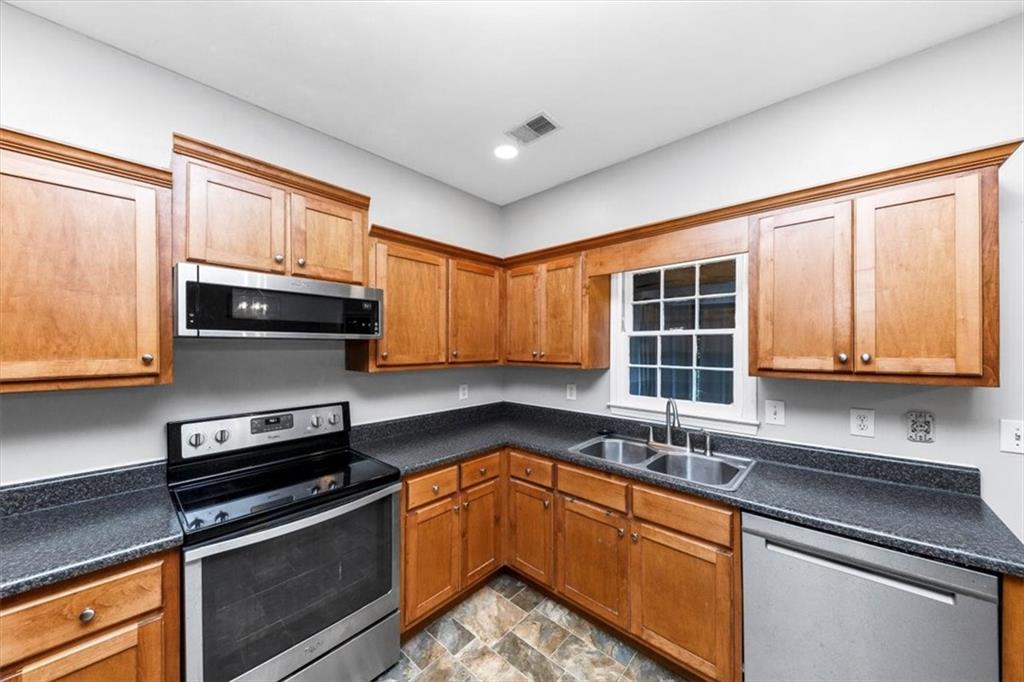 244 Freestone Lane Dallas, GA 30132 - Photo 10 of 26 a kitchen with granite countertop a sink stainless steel appliances and cabinets