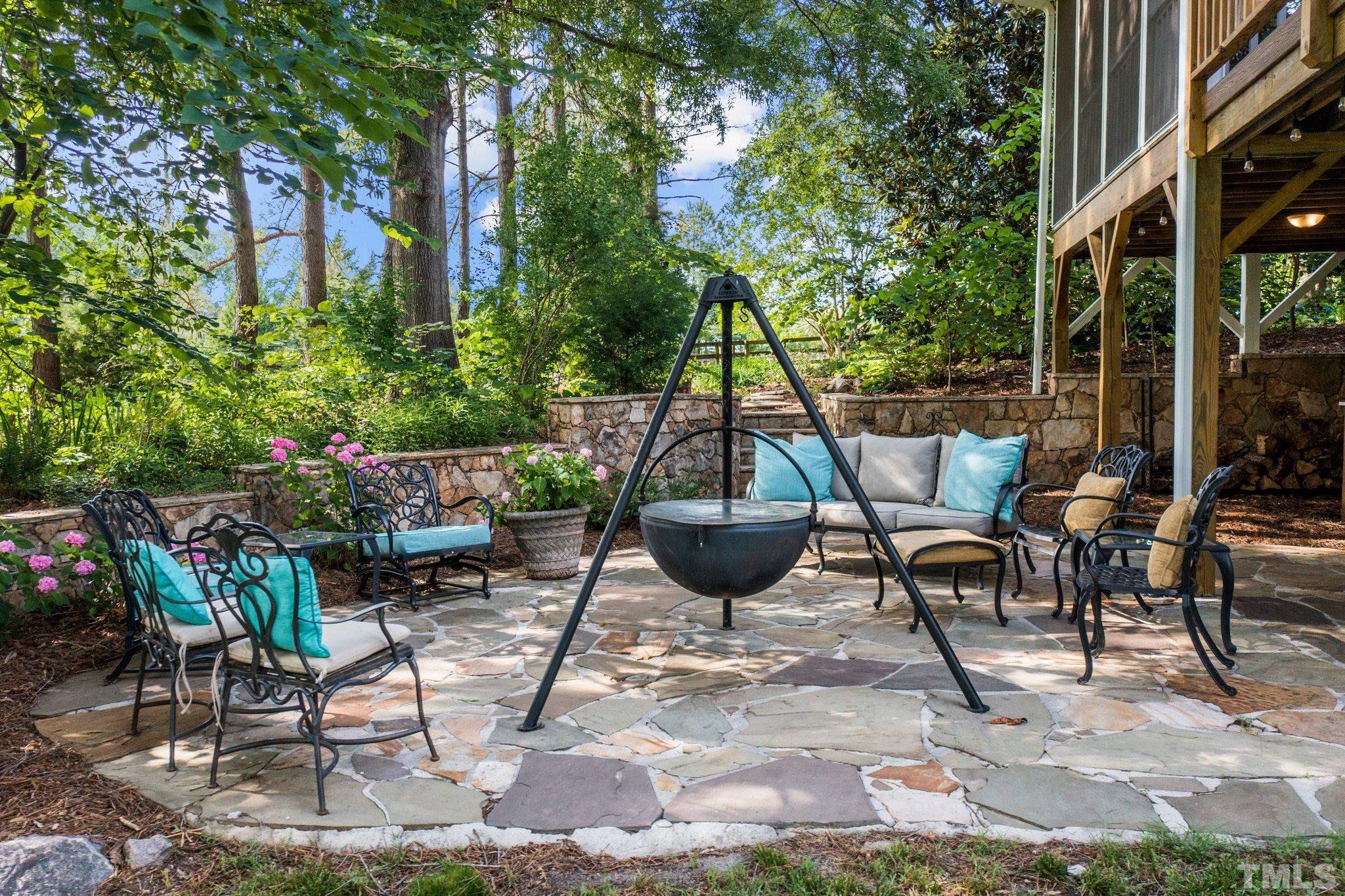 8737 Castleberry Road Apex, NC 27523 - Photo 24 of 99 a view of a patio with table and chairs potted plants and large tree