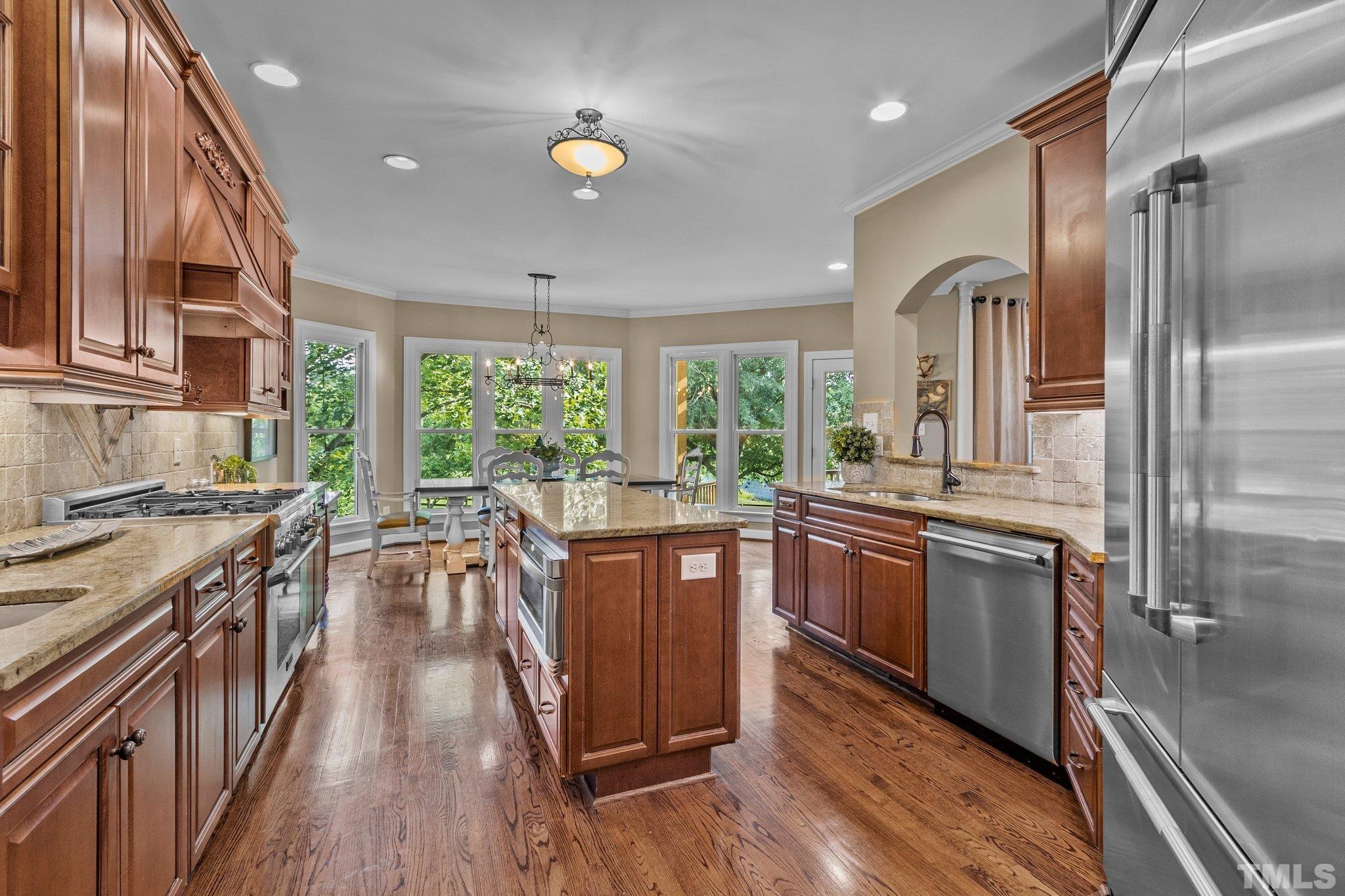 8737 Castleberry Road Apex, NC 27523 - Photo 34 of 99 a kitchen with stainless steel appliances granite countertop lots of counter top space and wooden floors