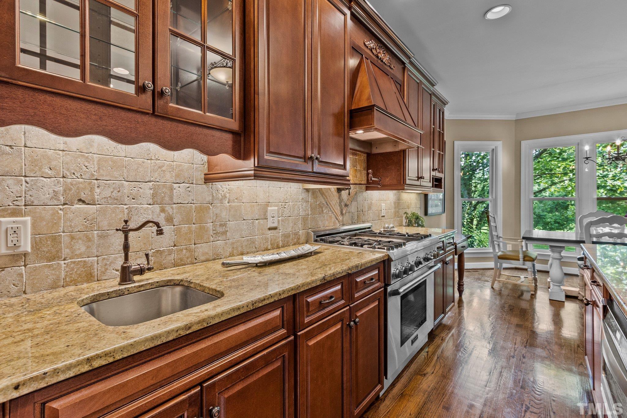8737 Castleberry Road Apex, NC 27523 - Photo 35 of 99 a kitchen with stainless steel appliances granite countertop a sink a stove and a wooden floors