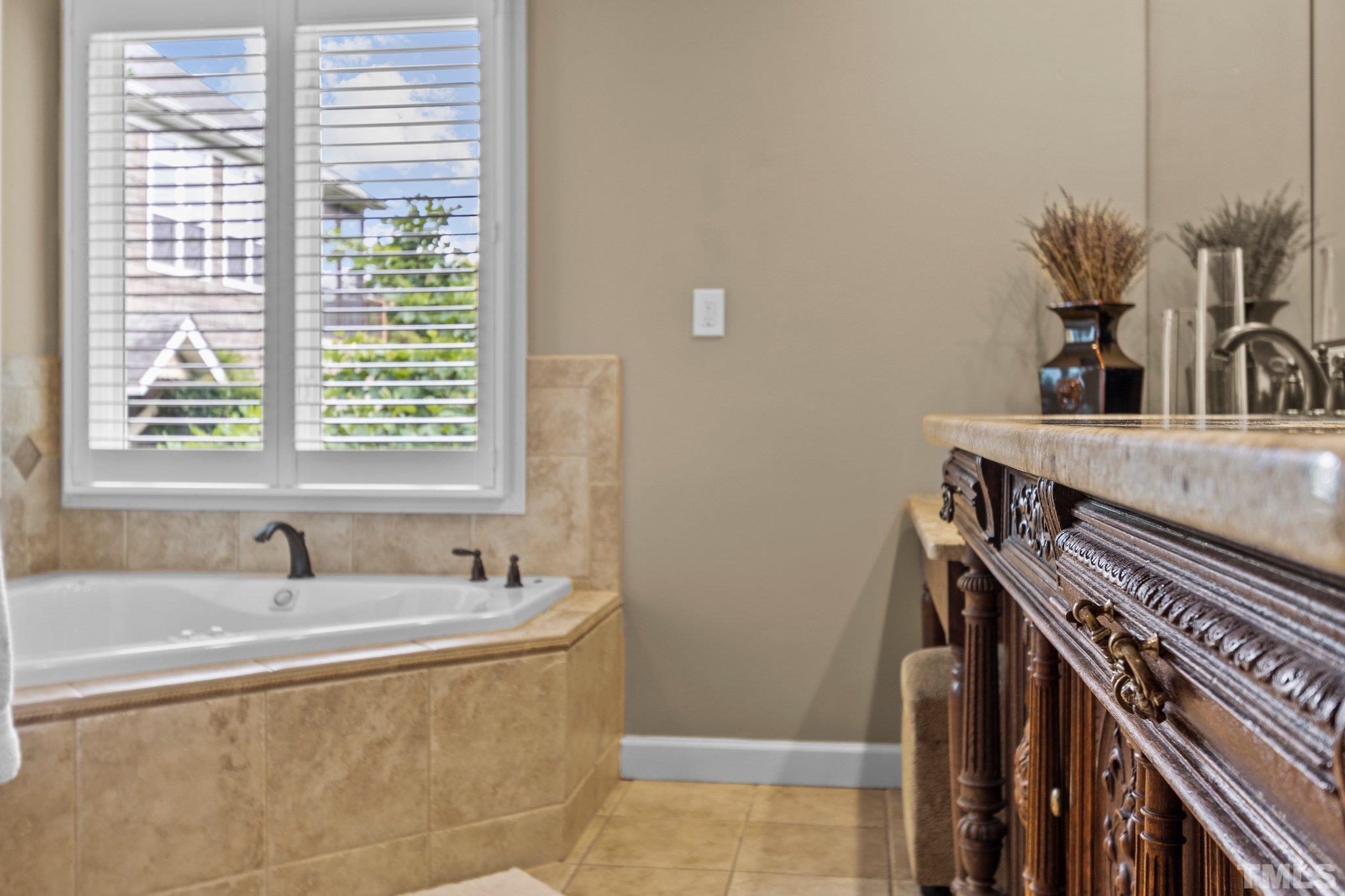 8737 Castleberry Road Apex, NC 27523 - Photo 49 of 99 a bathroom with a sink a vanity and a bathtub