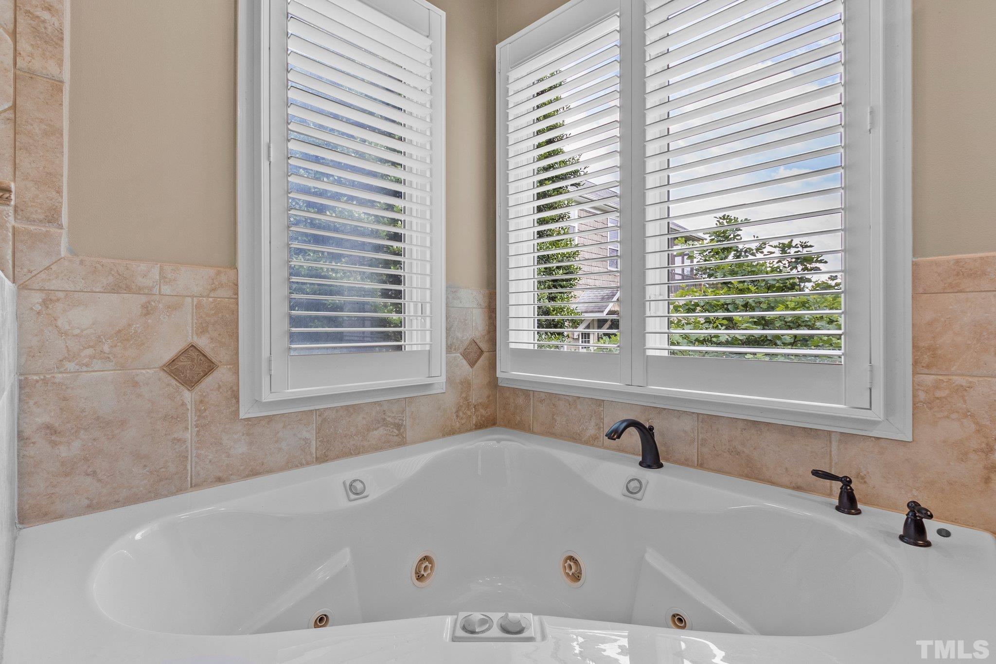 8737 Castleberry Road Apex, NC 27523 - Photo 50 of 99 a white bath tub sitting in a bathroom next to a window
