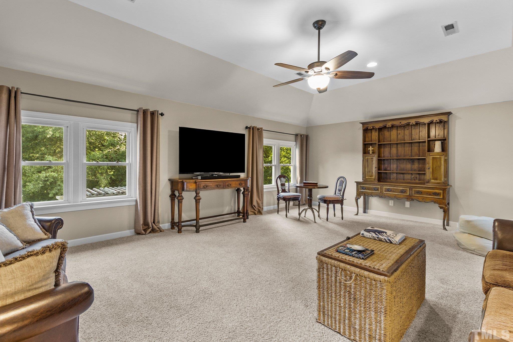 8737 Castleberry Road Apex, NC 27523 - Photo 62 of 99 a living room with furniture a flat screen tv and a window