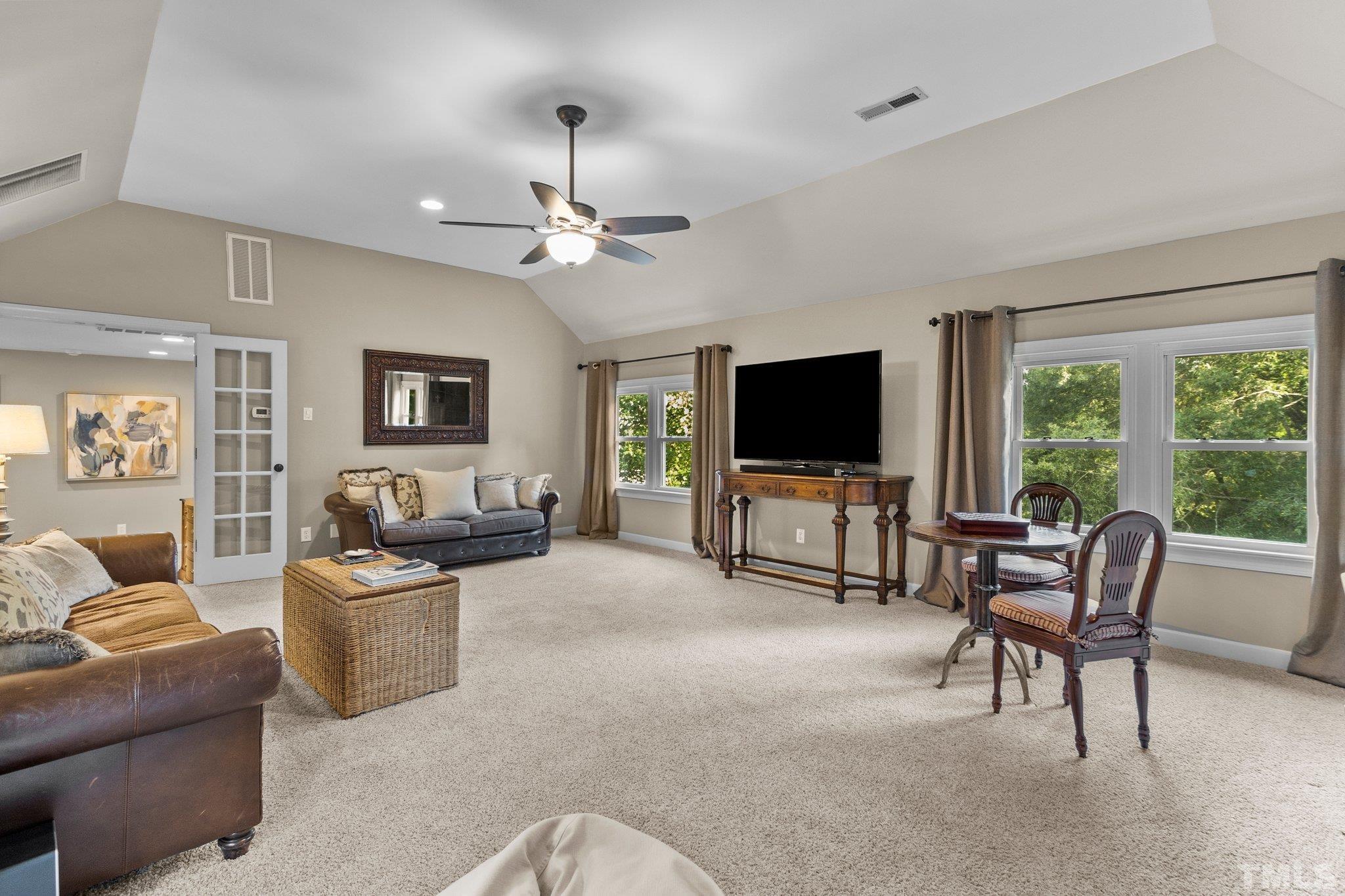8737 Castleberry Road Apex, NC 27523 - Photo 63 of 99 a living room with furniture and a flat screen tv