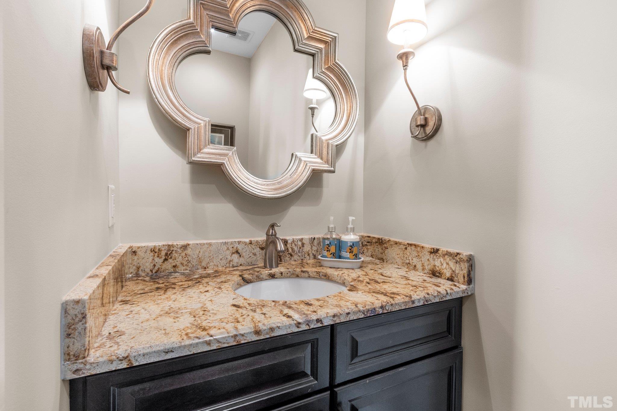 8737 Castleberry Road Apex, NC 27523 - Photo 83 of 99 a bathroom with a granite countertop sink and a mirror