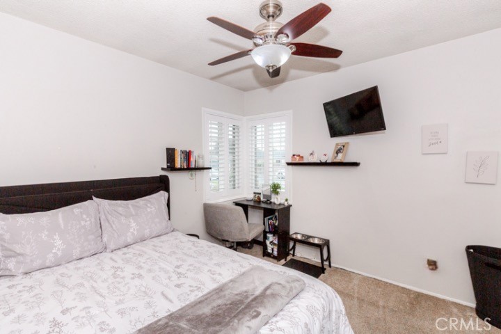11229 Elmhurst Drive Norwalk, CA 90650 - Photo 30 of 54 a bedroom with a bed a flat screen tv and a ceiling fan