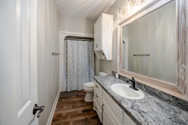 a spacious bathroom with a granite countertop sink a mirror and a shower