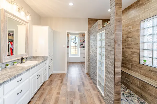 a bathroom with a granite countertop sink and a large mirror