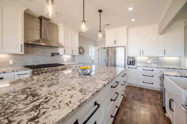 a kitchen with counter top space appliances and wooden floor