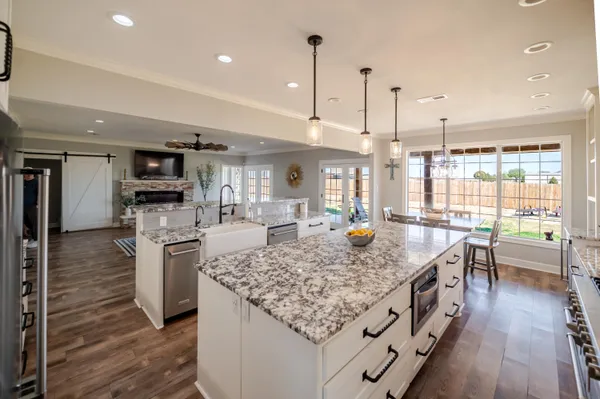 a kitchen with granite countertop a sink a stove and cabinets
