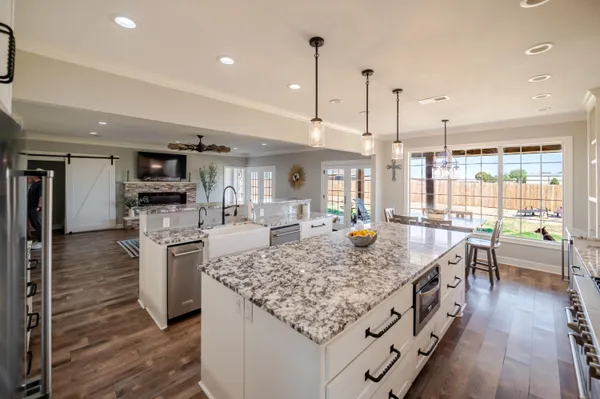 a kitchen with stainless steel appliances granite countertop a stove a sink and a white cabinets
