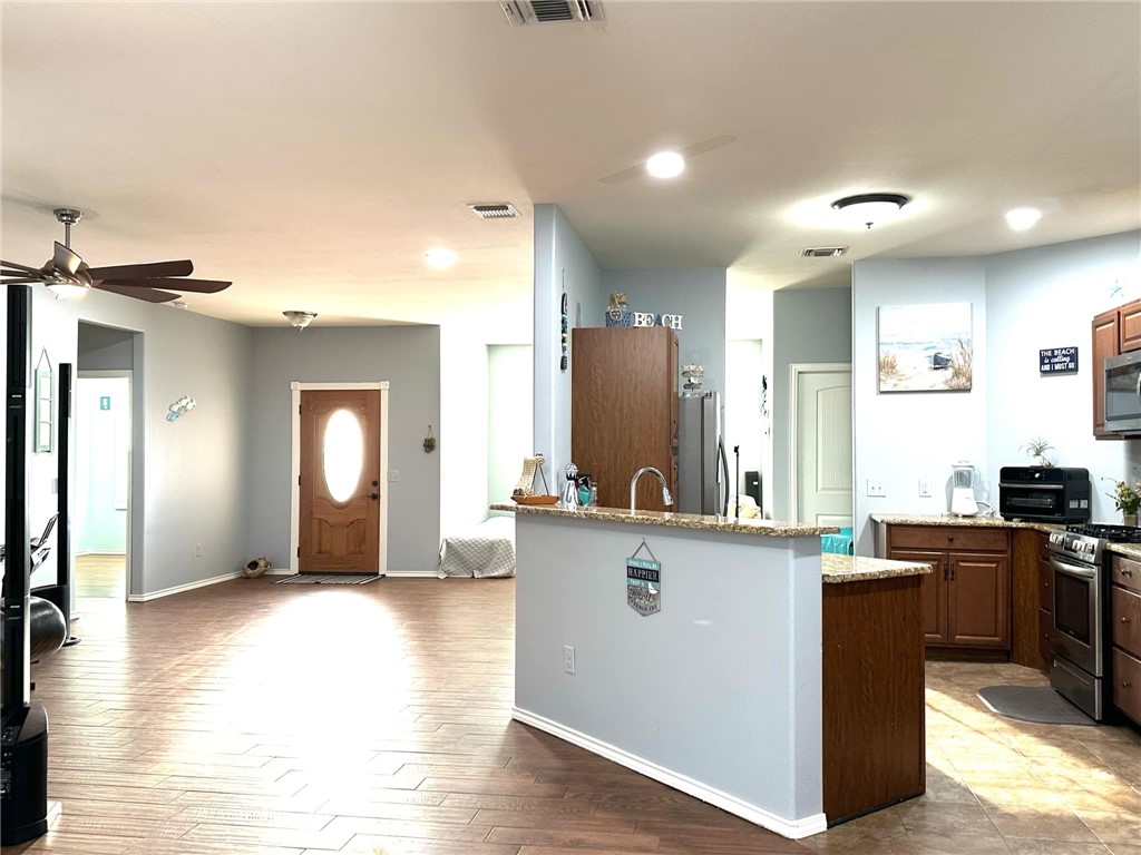 15517 Dyna Street Corpus Christi, TX 78418 - Photo 3 of 16 a kitchen with stainless steel appliances granite countertop a refrigerator a stove top oven and a sink