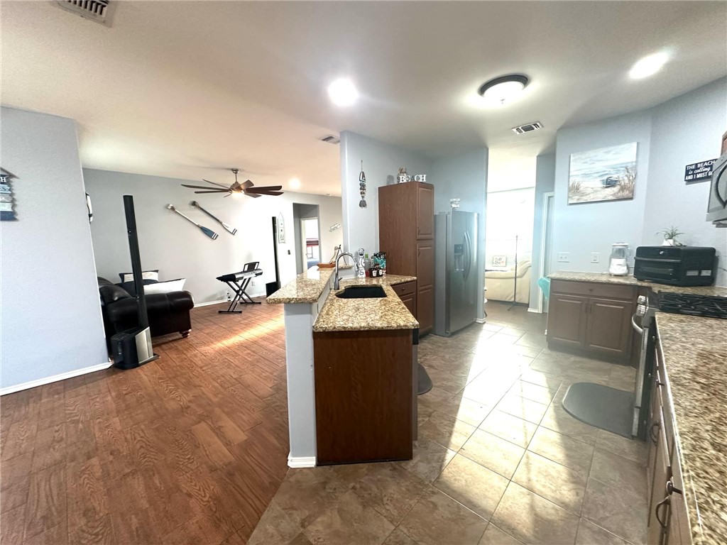 15517 Dyna Street Corpus Christi, TX 78418 - Photo 4 of 16 a kitchen with stainless steel appliances kitchen island granite countertop a refrigerator and a sink