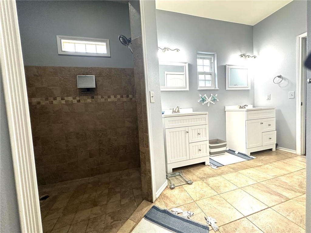 15517 Dyna Street Corpus Christi, TX 78418 - Photo 5 of 16 a bathroom with a sink a mirror and a shower