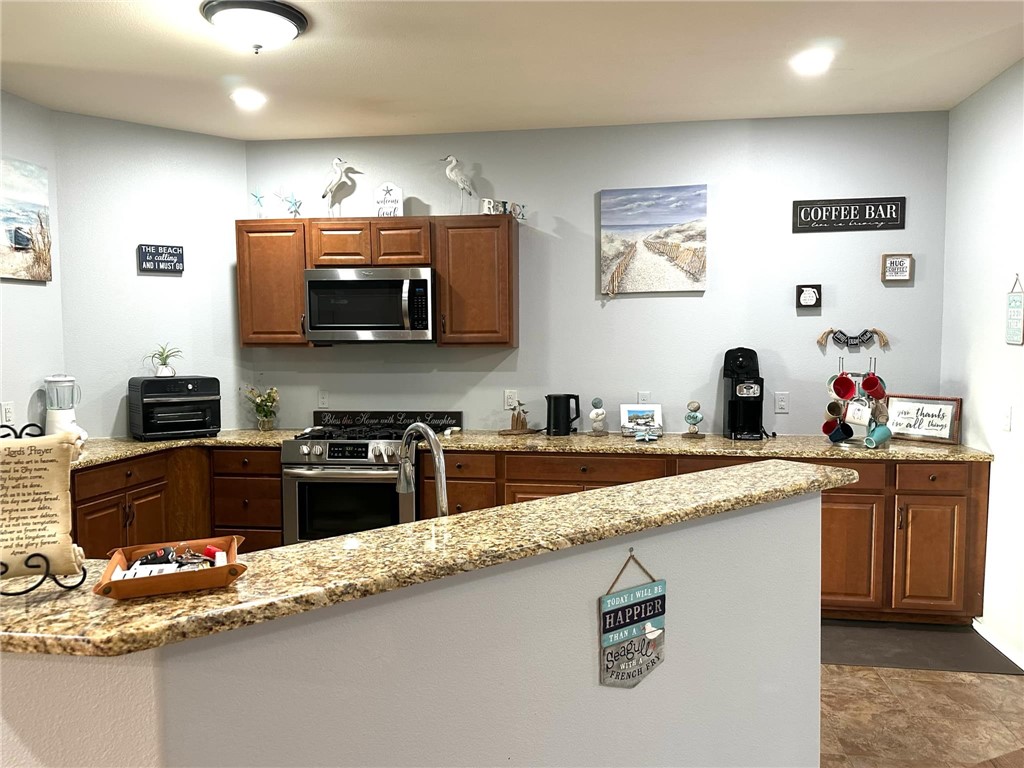 15517 Dyna Street Corpus Christi, TX 78418 - Photo 8 of 16 a kitchen with stainless steel appliances granite countertop a sink stove and cabinets