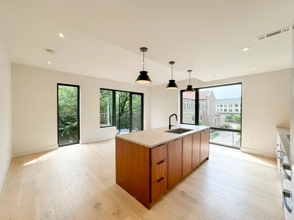 a kitchen with stainless steel appliances granite countertop a sink and a large window