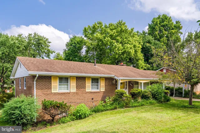 a front view of a house with a yard and potted plants