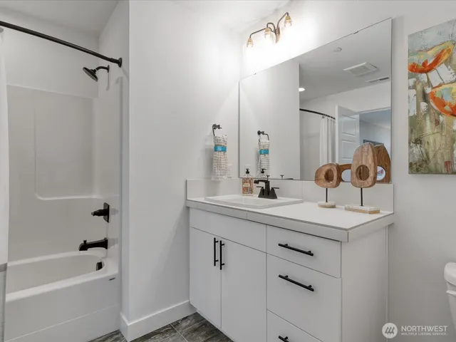 a bathroom with a bathtub sink vanity granite and shower