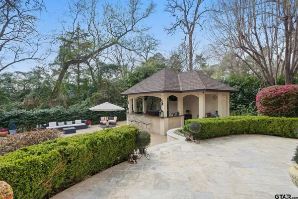a view of a white house that has a tree in front of it