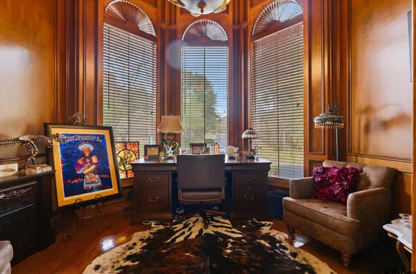 a living room with furniture fireplace and a large window