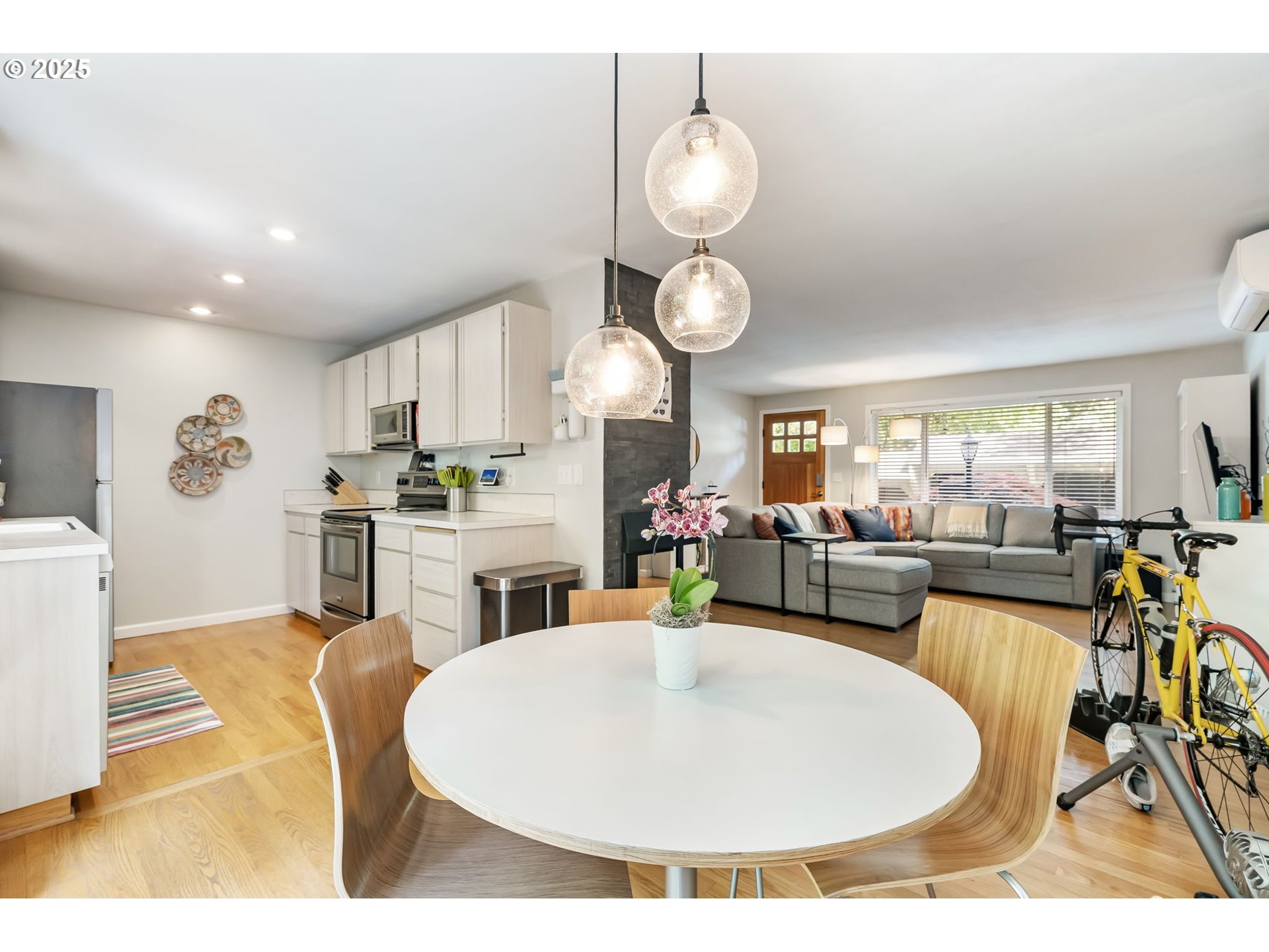 4560 Northwest Barnes Road Portland, OR 97210 - Photo 13 of 36 a living room with stainless steel appliances kitchen island granite countertop a stove a sink a dining table and chairs with wooden floor