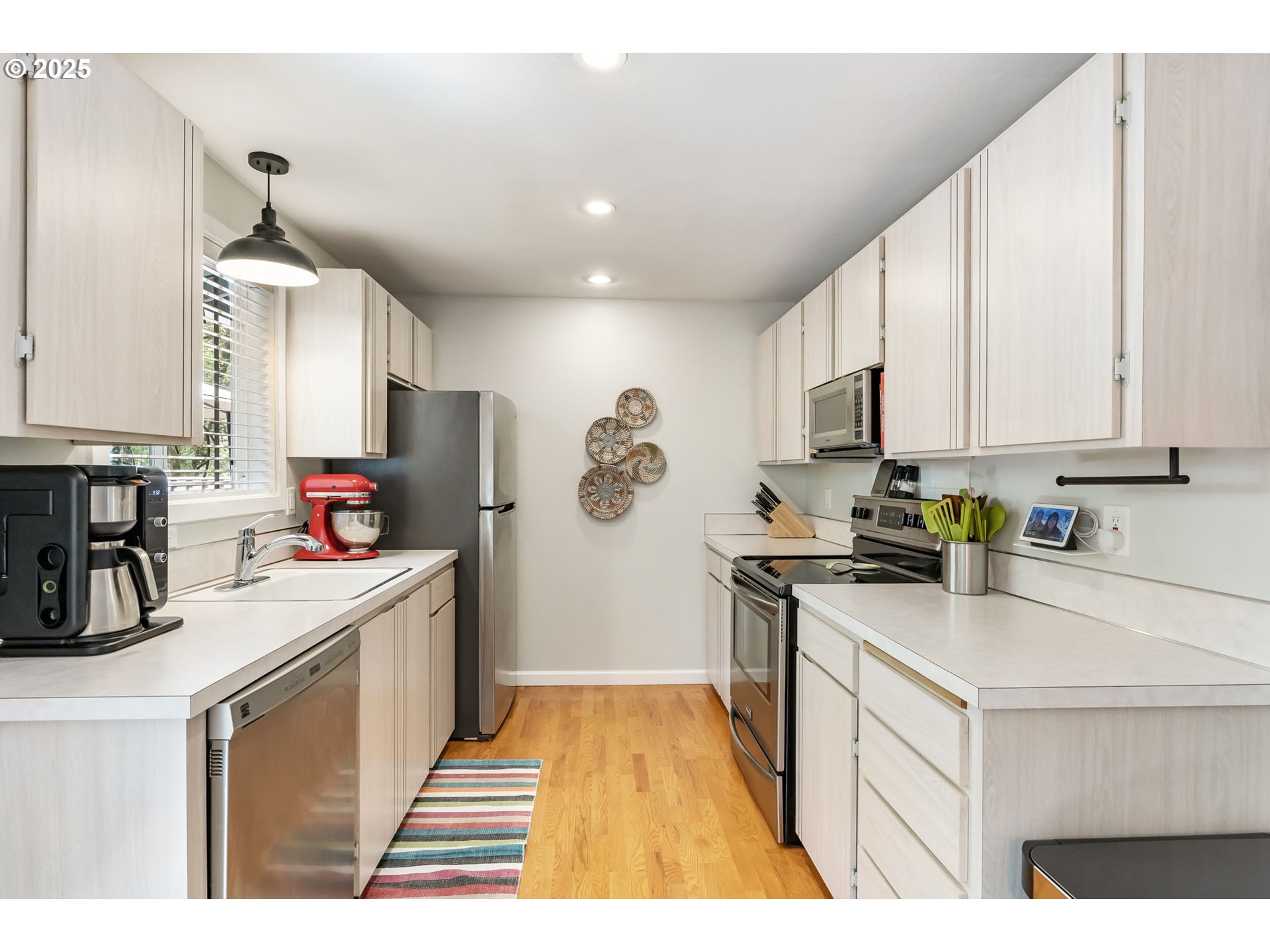 4560 Northwest Barnes Road Portland, OR 97210 - Photo 9 of 36 a kitchen with kitchen island granite countertop a sink appliances cabinets and a counter top space