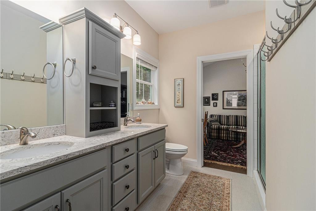 1229 Dean Hill Road Southeast Monroe, GA 30655 - Photo 45 of 51 a bathroom with a granite countertop sink a toilet and shower
