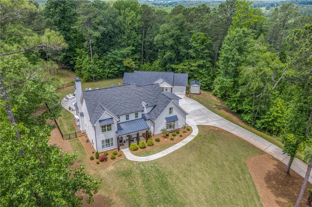 1229 Dean Hill Road Southeast Monroe, GA 30655 - Photo 48 of 51 an aerial view of a house with swimming pool and trees all around