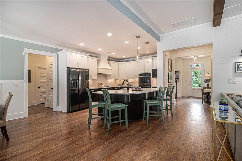 1229 Dean Hill Road Southeast Monroe, GA 30655 - Photo 8 of 51 a kitchen with stainless steel appliances kitchen island granite countertop a wooden table chairs and a stove