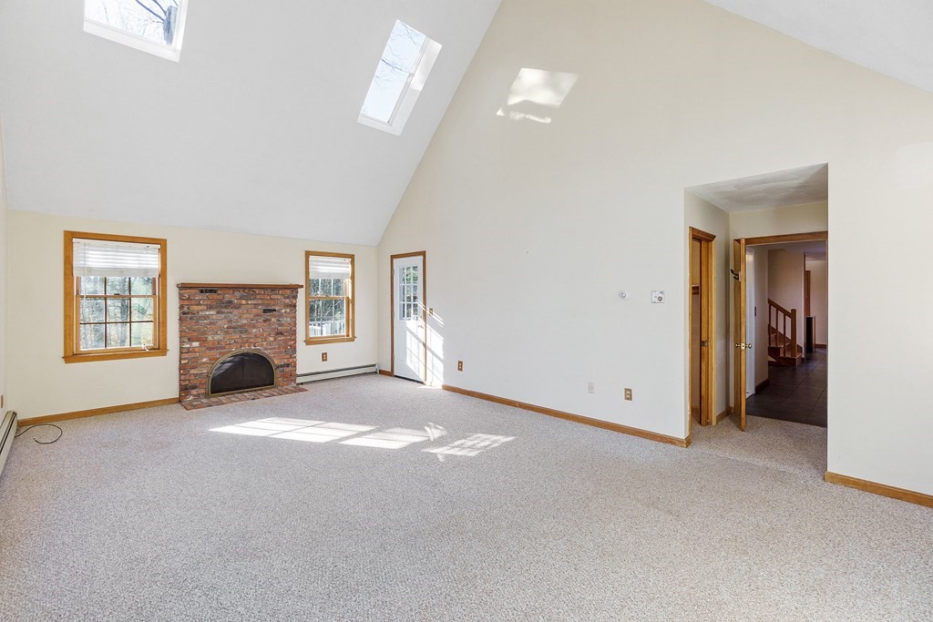 462 Lowell Road Groton, MA 01450 - Photo 15 of 42 a view of an empty room with a fireplace and a window