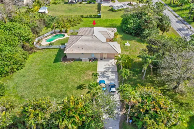 an aerial view of a house with swimming pool garden and patio