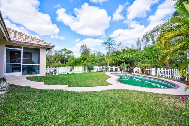 a view of a chairs and table in patio with a yard