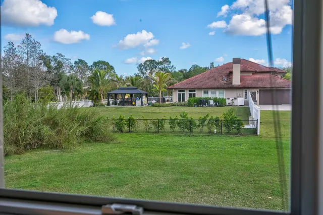 a dining room with wooden floor a chandelier a wooden table and chairs