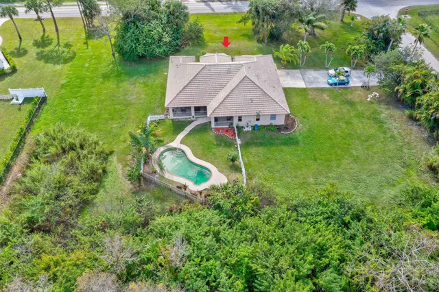 an aerial view of a house with a garden and lake view