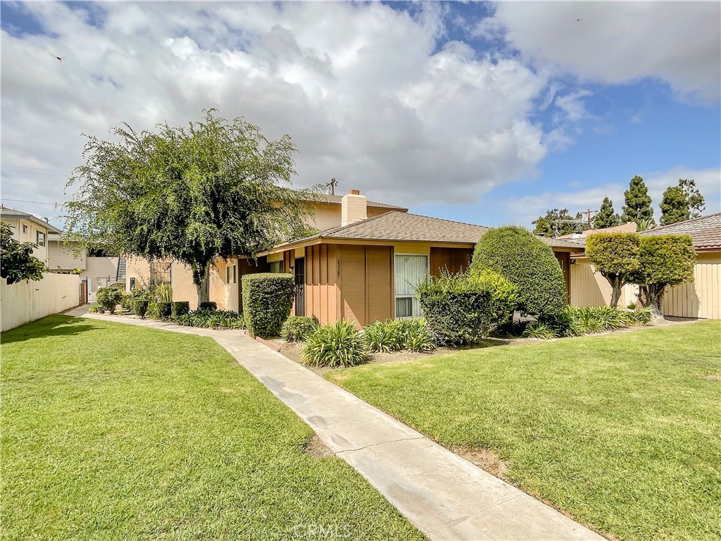 a front view of a house with a yard and trees