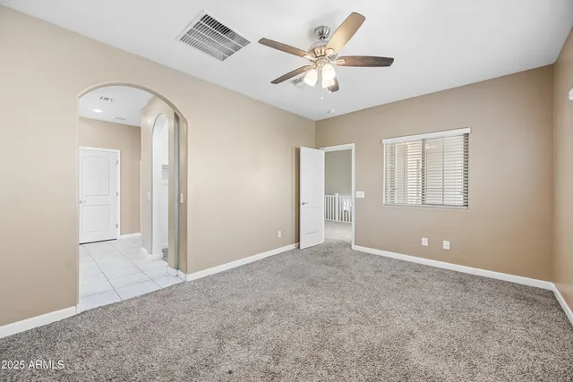 an empty room with a ceiling fan and a window