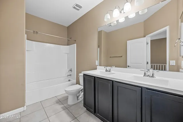 a spacious bathroom with a double vanity sink mirror and toilet