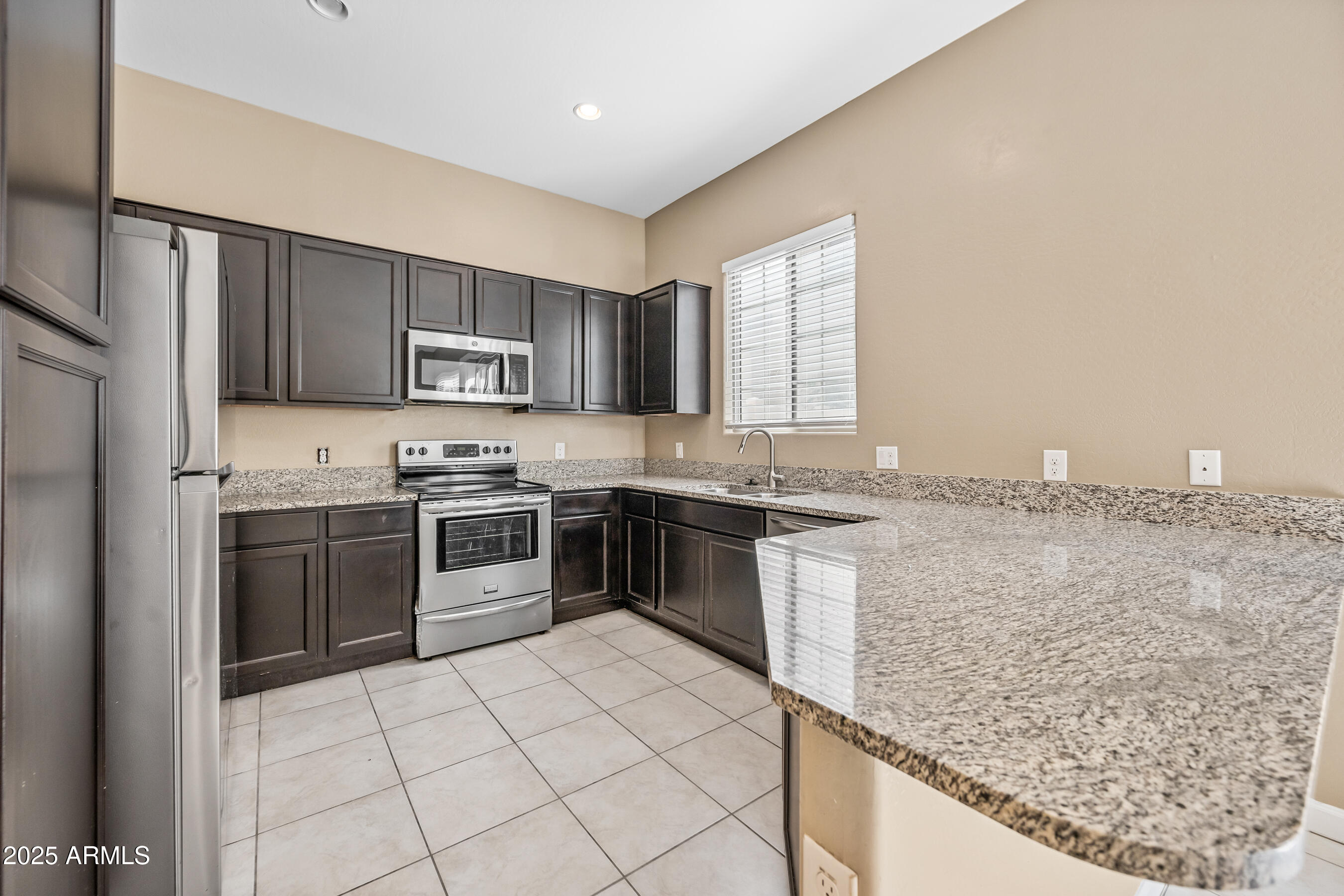 1367 South Country Club Drive, Unit 1131 Mesa, AZ 85210 - Photo 8 of 30 a kitchen with granite countertop a stove sink and cabinets